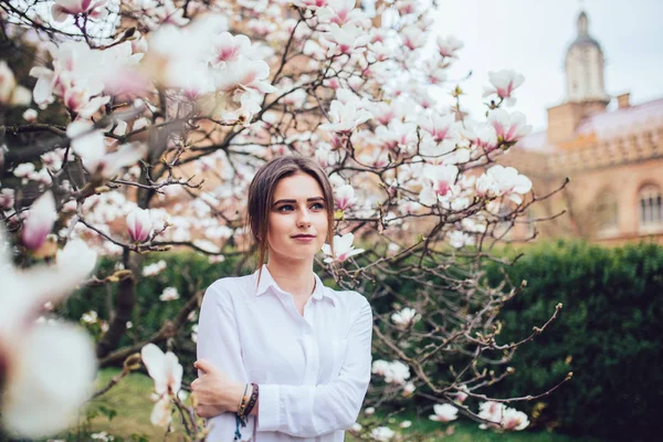 Bella giovane donna vicino all'albero primaverile in fiore. Fiore di magnetolia . — Foto Stock