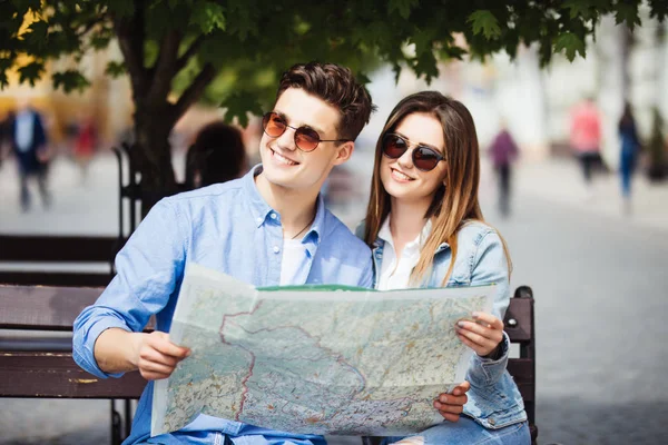 Unga lyckliga paret reser med kartor i hand i staden. Turist. — Stockfoto