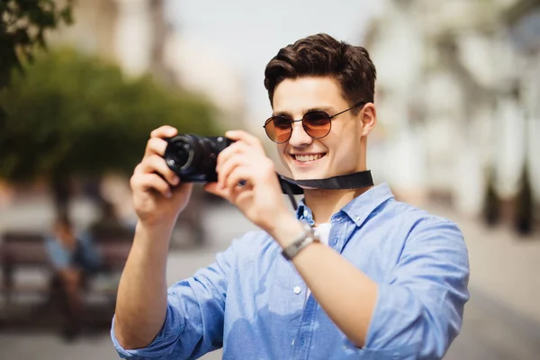 Toeristische Man met de Camera fotograferen op straat. Portret van knappe Glimlachende man vasthouden van de Camera en foto van interessante plaatsen tijdens het wandelen In de oude stad maken. — Stockfoto