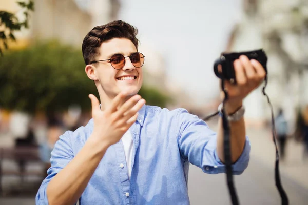 Stilig turist tar en selfie på kallelse. Ung man ler mot kameran i en urban scen. Kaukasiska personer. Konceptet om människor, livsstil och teknologi — Stockfoto