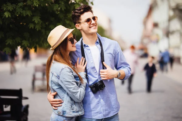 Jovem casal de turistas dar um passeio em uma rua da cidade calçada em um dia ensolarado — Fotografia de Stock