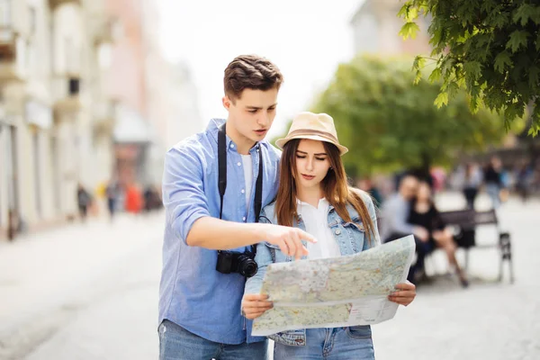 Летние каникулы, знакомства и туристическая концепция - улыбающаяся пара в солнечных очках с картой города — стоковое фото