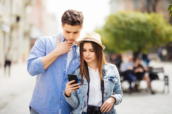 两位游客在新城市的街道搜索地点咨询智能手机 gps — 图库照片