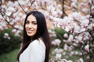 Şehvetli genç bahar kadın Manolya çiçek açan ağacında