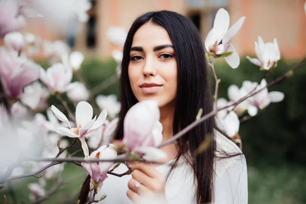 Giovane bella donna vicino magnolia albero in fiore. Carino giovane donna vicino albero di magnolia — Foto Stock