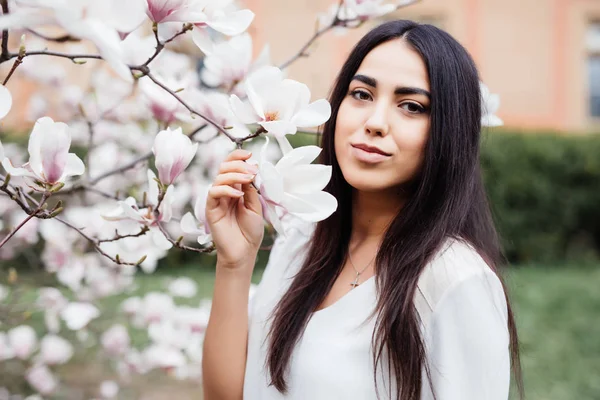 Fiatal gyönyörű fiatal nő, a virágzó Tavaszi fa közelében — Stock Fotó