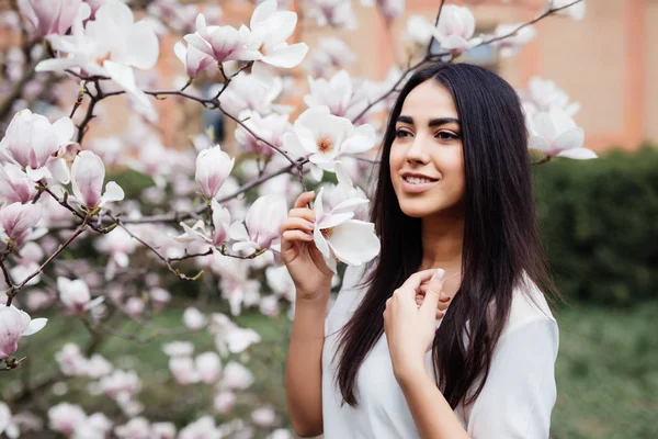 Ritratto di una giovane bella donna vicino all'albero di magnolia con fiori . — Foto Stock