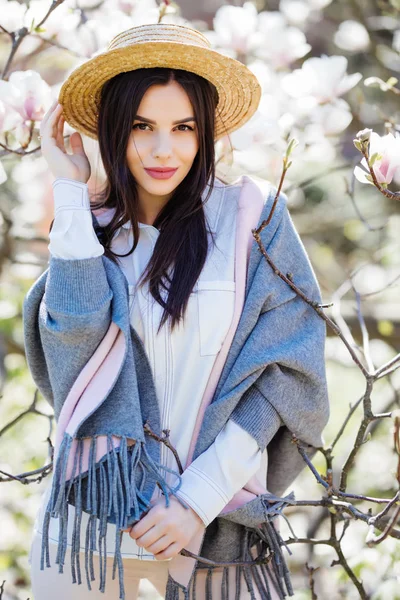 Joven hermosa chica caucásica en sombrero de paja en un floreciente jardín de magnolia primavera . —  Fotos de Stock
