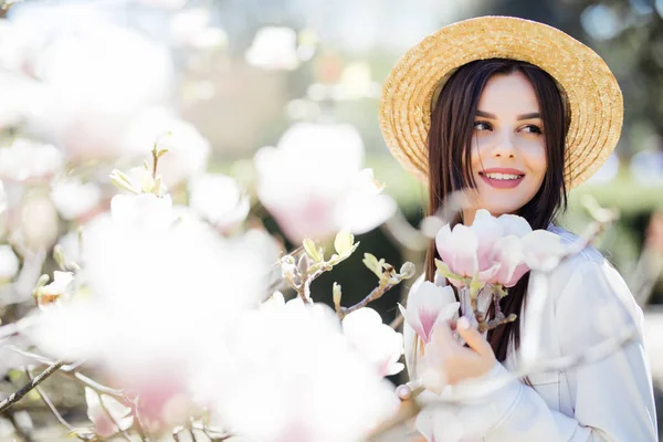 Portrait extérieur d'une jeune belle femme près d'un magnolia avec des fleurs . — Photo