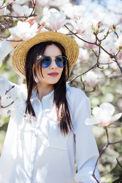 A fiatal szépség nő élvezi a meleg tavaszi időjárás és az illatos magnolia — Stock Fotó