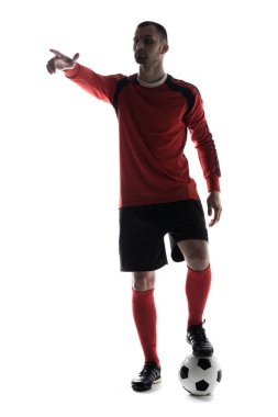 Beyaz arka plan üzerinde izole futbol topu ile parmak ile işaret genç futbolcu silüeti