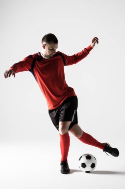 Beyaz arka plan üzerinde izole tekme oynarken futbol oyuncu adam silüeti