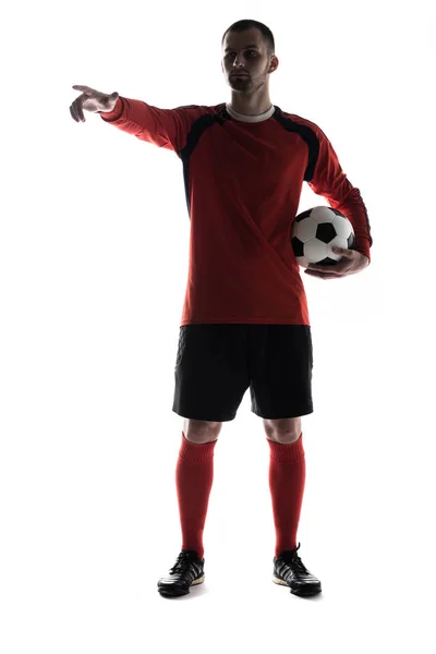 Silueta de joven jugador apuntando con el dedo con pelota de fútbol en manos aisladas sobre fondo blanco — Foto de Stock