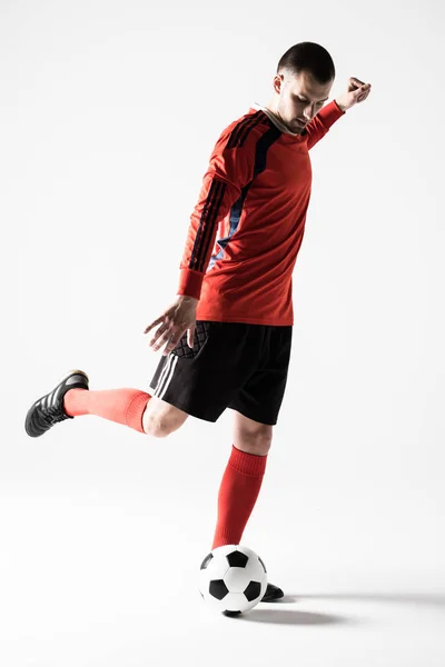 Silhueta de jovem jogador de futebol chute bola isolada no fundo branco — Fotografia de Stock