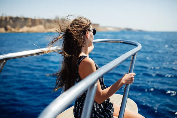 Молодая женщина в солнечных очках отдыхает на яхте в море. Красивый морской пейзаж — стоковое фото
