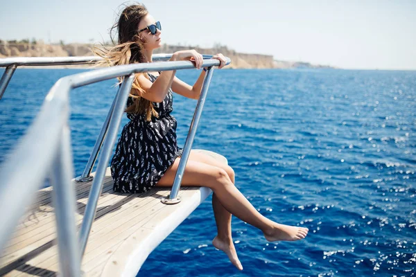 Fiatal nő fekszik, a tenger és a horizont szeretnének egy luxushajón — Stock Fotó