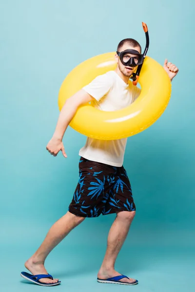 Volledige lengte van de knappe jongeman met opblaasbare gele ring en snorkel masker runing weg geïsoleerd op groene achtergrond — Stockfoto
