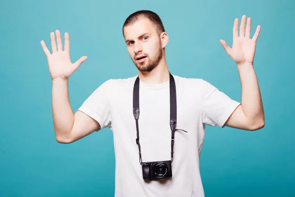 Imagen de joven fotógrafo guapo emocional sosteniendo cámara aislada sobre fondo de pared verde —  Fotos de Stock
