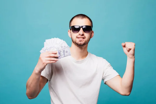 Retrato de un joven hombre de verano en camiseta blanca sosteniendo dinero en efectivo éxito grito mientras sonríe aislado sobre fondo verde —  Fotos de Stock