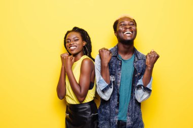 Çığlık ve sarı üzerinde izole kutluyor mutlu bir genç afro Amerikan çift portresi