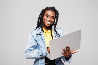 Beyaz bitti izole dizüstü bilgisayar kullanan mutlu genç afro Amerikan kadın portresi