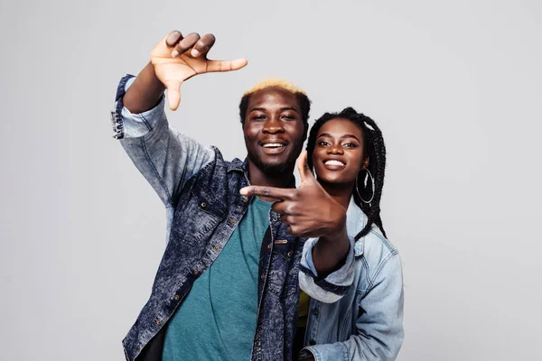 Portrait of a happy afro american couple make frame gesture isolated over white