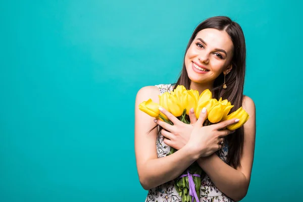 Tavaszi női nap. a zöld háttér elszigetelt kezében sárga tulipán csokor mosolygó nő portréja — Stock Fotó