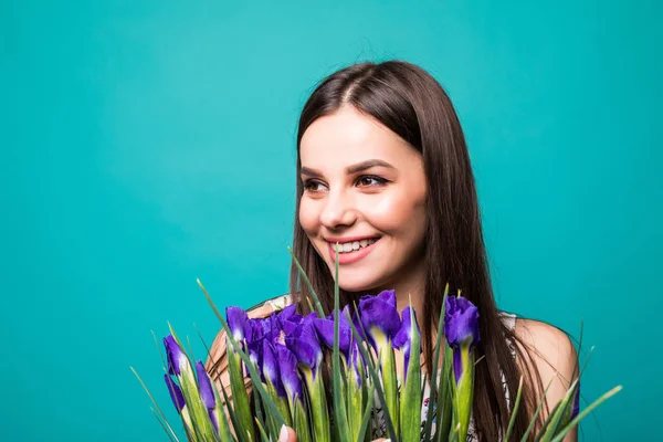 Festa della donna. Ritratto di una giovane donna allegra con bouquet di iris isolato su sfondo blu — Foto Stock