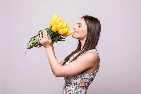 Questo aroma primaverile. Giovane donna carina con bouquet di tulipani gialli isolati su sfondo bianco — Foto Stock