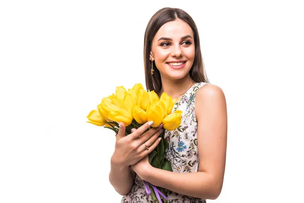 Retrato jovem de mulher com flores tulipas amarelas em mãos em um fundo leve — Fotografia de Stock