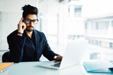 Karışık Hintli işadamı laptop Office çalışma. Dizüstü bilgisayar ile onun masasında proje üzerinde genç Hintli.