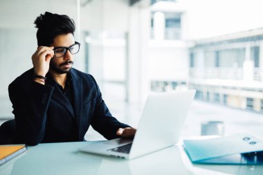 Karışık Hintli işadamı laptop Office çalışma. Dizüstü bilgisayar ile onun masasında proje üzerinde genç Hintli.