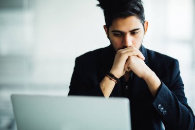 Gülümseyen ve ofiste çalışan Concetrated Hintli adam