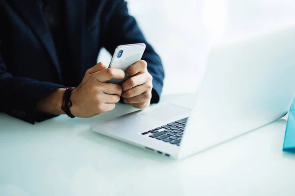 Close up van zakenman met behulp van mobiele telefoon en laptopcomputer op balie in moderne kantoor — Stockfoto