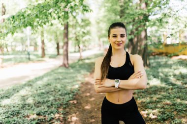 Göğsünün geçti ve park kamerada bakarak elleri koşu ayakta için kıyafetleri ile güzel ve atletik kız
