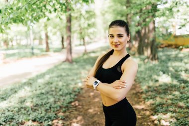 Göğsünün geçti ve park kamerada bakarak elleri koşu ayakta için kıyafetleri ile güzel ve atletik kız