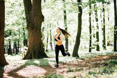 Siyah top Park'ta jogging içinde güzel ve genç birbayan. Sağlıklı kız yaşam tarzı arka plan kopya alanı ile