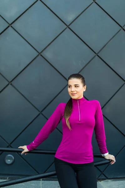 Fitness sport girl en ropa deportiva haciendo ejercicio de yoga fitness en la calle en la pared negra, deportes al aire libre, estilo urbano — Foto de Stock