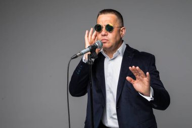 Bir mikrofon ile bir şarkı söylerken, bir olayın başvuran veya bir parti adamı mutlu ve motive, orta yaşlı, izole anın tadını çıkarın