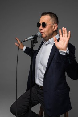 Bir mikrofon ile bir şarkı söylerken, bir olayın başvuran veya bir parti adamı mutlu ve motive, orta yaşlı, izole anın tadını çıkarın