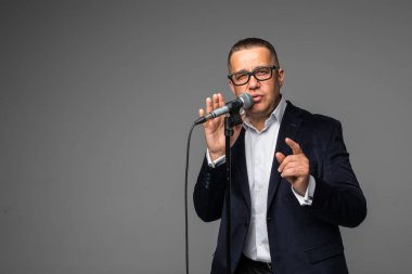 Bir mikrofon ile bir şarkı söylerken, bir olayın başvuran veya bir parti adamı mutlu ve motive, orta yaşlı, izole anın tadını çıkarın