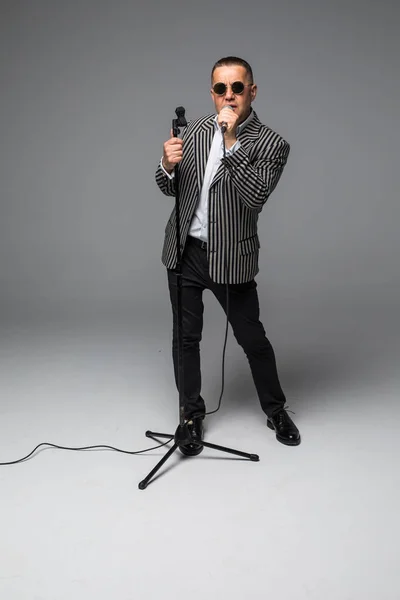 Entrevistador Showman de mediana edad con emociones. Joven hombre maduro elegante sosteniendo micrófono sobre fondo blanco. Concepto Showman . — Foto de Stock