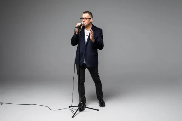 Entrevistador Showman de mediana edad con emociones. Joven hombre maduro elegante sosteniendo micrófono sobre fondo blanco. Concepto Showman . — Foto de Stock