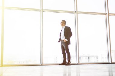 Ofis panoramik pencere bakarak üst düzey iş adamı