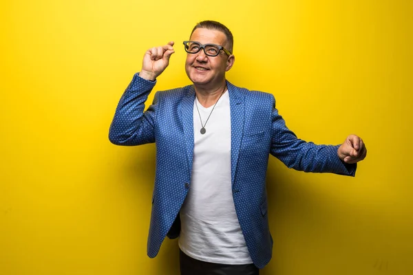 Retrato de hombre feliz y divertido de mediana edad en traje y gafas aisladas sobre fondo amarillo — Foto de Stock