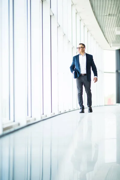 Homme d'affaires mature senior marchant dans un immeuble de bureaux moderne. Homme d'affaires prospère portant costume et cravate . — Photo