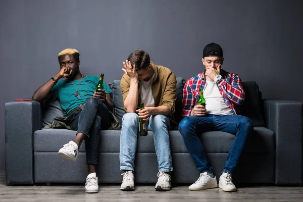 Triste amigos do sexo masculino com cerveja assistindo esportes na TV em casa — Fotografia de Stock