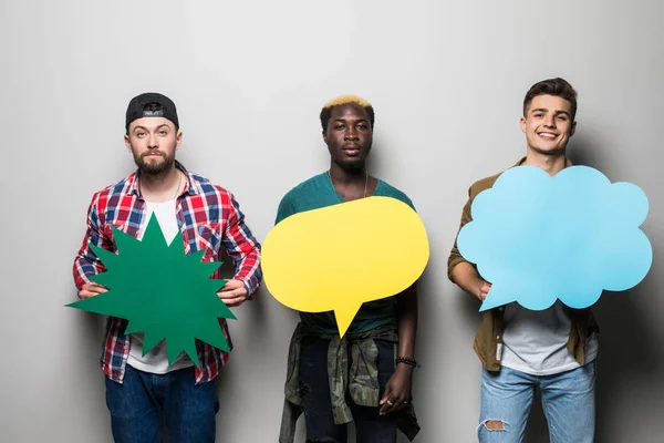 Trois jeunes hommes métis amis avec des bulles d'expression isolés sur fond gris — Photo