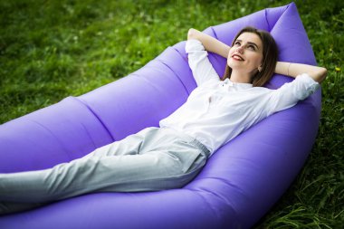 Düğün seviyorum. Genç ve güzel kadın güneş Park'ta çimenlerin üzerinde dinlenme sırasında şişme kanepe lamzac yalan