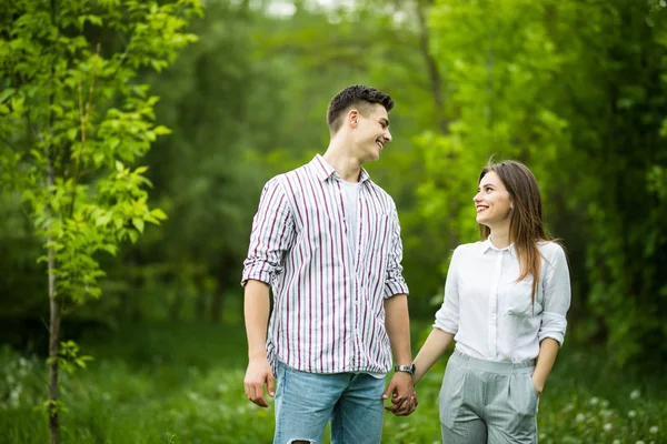 Vacker ung i kärlekspar som tar en promenad i stadsparken — Stockfoto